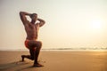 Handsome young muscular male model doing the workout stretching warm up on the beach summer.sexy athlete abs and perfect Royalty Free Stock Photo