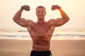 Handsome young muscular male model doing the workout stretching warm up on the beach summer.sexy athlete abs and perfect Royalty Free Stock Photo