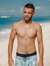 Handsome young muscular man posing shirtless on ocean beach, summer time. Ideal slim fit body Royalty Free Stock Photo