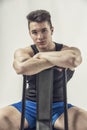 Handsome young muscular man sitting on chair Royalty Free Stock Photo