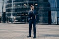 Handsome young office worker in dark blue formal suit speaks on cellphone Royalty Free Stock Photo