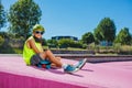 Handsome young preteen boy with green hair sit on ramp