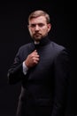 Handsome young priest with bread posing on a black background.