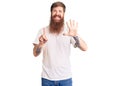 Handsome young red head man with long beard wearing casual white tshirt showing and pointing up with fingers number six while Royalty Free Stock Photo