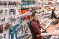 A handsome young seller of locksmith tools at his workplace at a table from a computer. Russian text: checkout