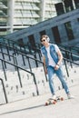 handsome young skater in headphones riding longboard in front Royalty Free Stock Photo