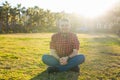 Handsome young smiling man sitting on the grass at park. Summer in the city concept. Royalty Free Stock Photo