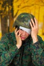 Handsome young soldier wearing uniform suffering from stress, with a white bandage around his head and covering his eye Royalty Free Stock Photo