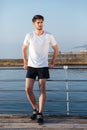 Handsome young sportsman standing on pier Royalty Free Stock Photo