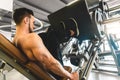 Handsome young sporty male bodybuilder with naked torso doing exercises for the legs in the gym Royalty Free Stock Photo