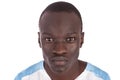 A handsome young Sudanese man with a bland expression looking directly at the camera in thought.