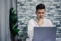 Handsome young thinking while serious working at home with laptop on desk