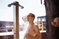 Handsome young topless caucasian man taking an outdoor shower on beach. Royalty Free Stock Photo