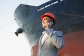 A young stylish man in a protective helmet against the backdrop of a seaport Royalty Free Stock Photo