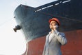 A young stylish man in a protective helmet against the backdrop of a seaport Royalty Free Stock Photo