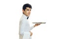 Handsome young waiter holding a tray empty food