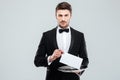 Handsome young waiter in tuxedo holding tray Royalty Free Stock Photo