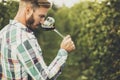 Young winemaker tasting red wine in vineyard