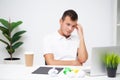 Handsome young worker working in a company office with documents and a laptop Royalty Free Stock Photo