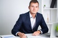 Handsome young worker working in a company office with documents and a laptop Royalty Free Stock Photo