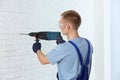 Handsome young working man using rotary hammer. Home repair Royalty Free Stock Photo