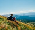 Handsomeyoung man sitting on rocky cliff and enjoying nature Royalty Free Stock Photo