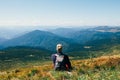 Handsomeyoung man sitting on rocky cliff and enjoying nature Royalty Free Stock Photo