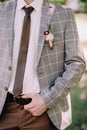 Handsone groom brown trousers and grey checkered