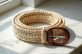 Handwoven rope belt with wooden buckle on marble surface Royalty Free Stock Photo