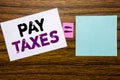 Handwriting Announcement text showing Pay Taxes. Business concept for Taxation Overtax Return written on sticky note paper on wood