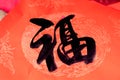 The Handwriting Chinese blessing Fu on the red paper with Chinese dragon pattern background.