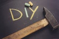 handwriting diy text with coloruful chalk and wooden hammer. Royalty Free Stock Photo