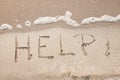 Handwriting message word help at sea beach sand Royalty Free Stock Photo