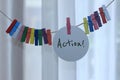 Handwriting single word - ACTION. Inspirational motivational notes on tag label paper hanging on rope with colorful wooden clips