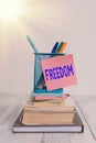 Handwriting text Freedom. Concept meaning liberty rather than in confinement or under physical restraint Stacked books pens metal Royalty Free Stock Photo