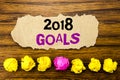 Handwriting text 2018 Goals. Concept for New Yer resolutions Written on sticky note paper reminder, wooden background with stick