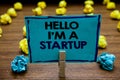 Handwriting text Hello I am A Startup. Concept meaning Entrepreneur starting business Presenting New project Blurry wooden deck ye