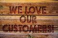 Handwriting text We Love Our Customers Call. Concept meaning Client deserves good service satisfaction respect Wooden background v