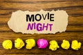 Handwriting text Movie Night. Concept for Wathing Movies Written on sticky note paper reminder, wooden background with sticky, Royalty Free Stock Photo