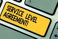 Handwriting text Service Level Agreement. Concept meaning Commitment between a service provider and a client Keyboard