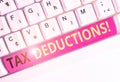 Handwriting text Tax Deductions. Concept meaning reduction income that is able to be taxed of expenses White pc keyboard