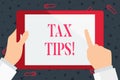 Handwriting text Tax Tips. Concept meaning compulsory contribution to state revenue levied by government Hand Holding