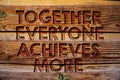 Handwriting text Together Everyone Achieves More. Concept meaning Teamwork Cooperation Attain Acquire Success Wooden background vi