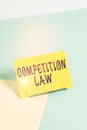 Handwriting text writing Competition Law. Concept meaning regulating the monopoly and unfair business practices Paper placed