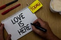 Handwriting text writing Love Is Here. Concept meaning Romantic feeling Lovely emotion Positive Expression Care Joy Man holding ma