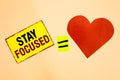 Handwriting text writing Stay Focused. Concept meaning Be attentive Concentrate Prioritize the task Avoid distractions Yellow piec Royalty Free Stock Photo