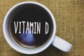 Handwriting text writing Vitamin D. Concept meaning Benefits of sunbeam exposure and certain fat soluble nutriments Mug coffee tho
