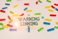 Handwriting text writing Warning Sinning. Concept meaning stop the action which is believed to break the laws Colored clothespin