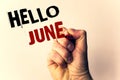 Handwriting text writing Hello June. Concept meaning Starting a new month message May is over Summer startingMan holding pen point