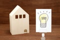 Handwritten bulb illustration and house on wood.